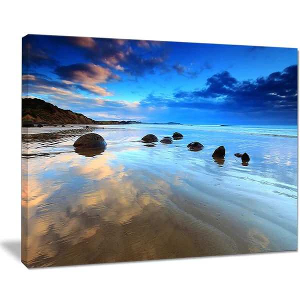 Design Art 'Cloudy Sky Over Moeraki Boulders' Photographic Print on Wrapped Canvas - Size: 16 inch H x 32 inch W x 1 inch D, Blue