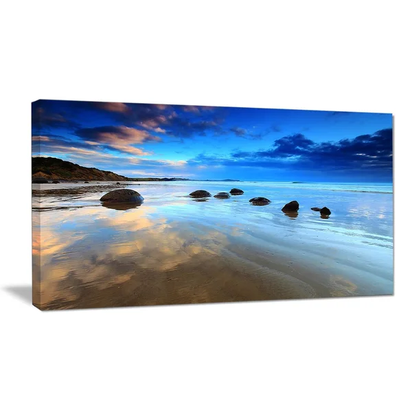 Design Art 'Cloudy Sky Over Moeraki Boulders' Photographic Print on Wrapped Canvas - Size: 16 inch H x 32 inch W x 1 inch D, Blue
